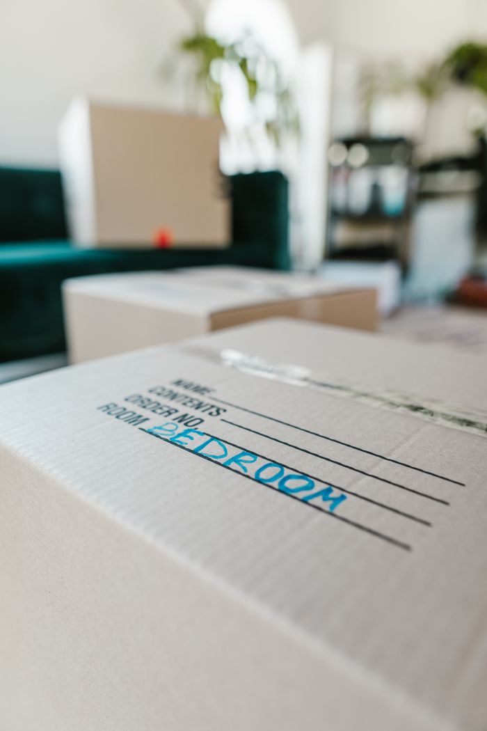 Packed cardboard box labeled Bedroom indoors, ready for moving.